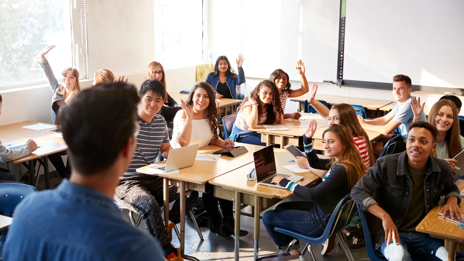 Professor em pé diante da turma durante a aula — uso intenso da voz, situação típica de quem desenvolve nódulos vocais.